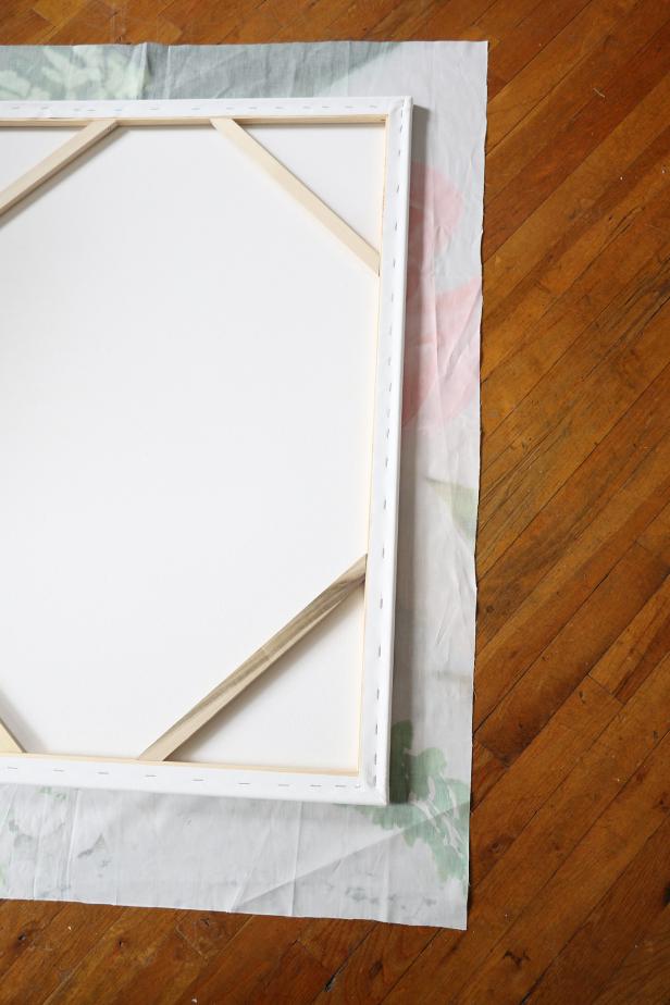 Place the canvas, also face down, on top of the fabric. Be sure to have a few inches of the fabric all around the canvas.