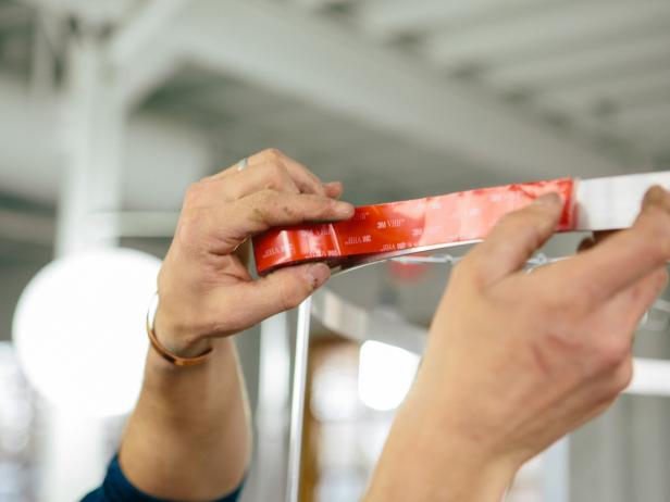 Apply double-stick tape to aluminum bars to make a pendant light.