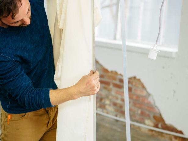 Attach the flat sheet to the double-sided tape making sure that the vertical seam of the fabric is centered on one of the vertical 4’ flat bars.