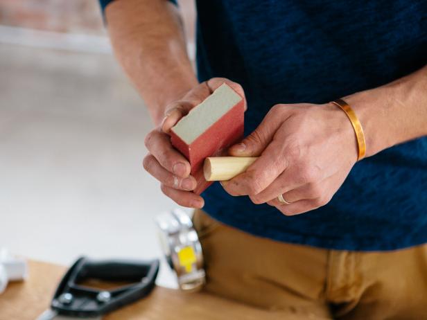 Use a sanding block to smooth out rough edges of wood dowels.