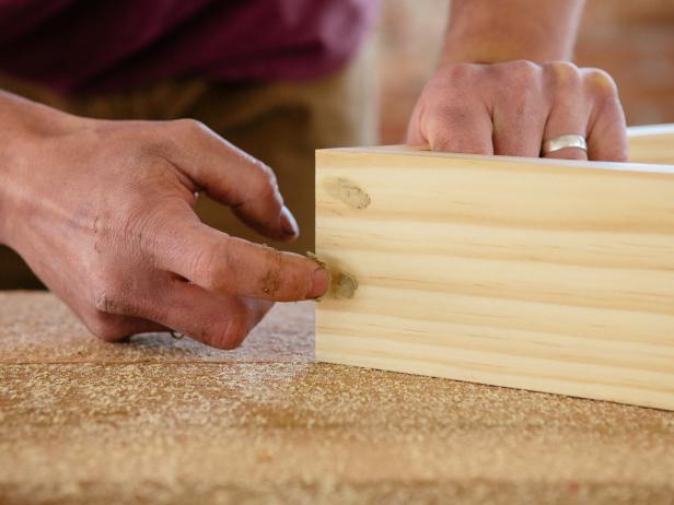 Fill nail holes with putty to finish making a triangle wood shelf.