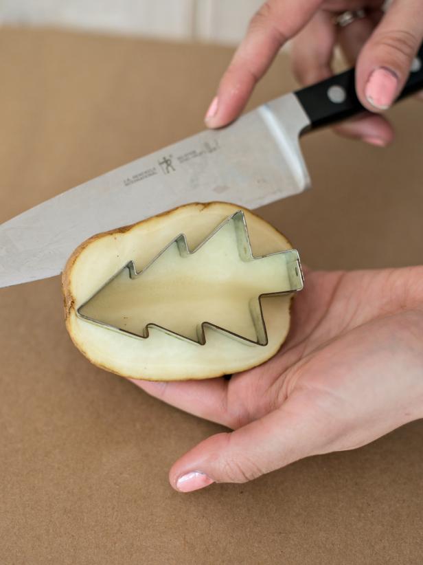 Cut around the cookie cutter at about 1/2" depth, so part of the potato inside cookie cutter will protrude 1/2". Remove cut portion of the potato around cookie cutter. Remove cookie cutter from the potato.