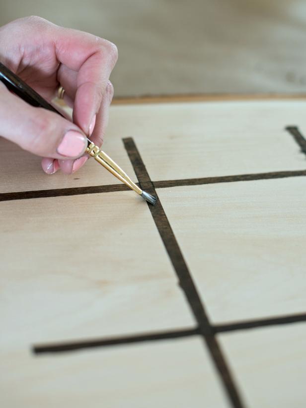 Use 1/2" natural bristle brush to apply wood stain inside cut lines to make a tic-tac-toe board.