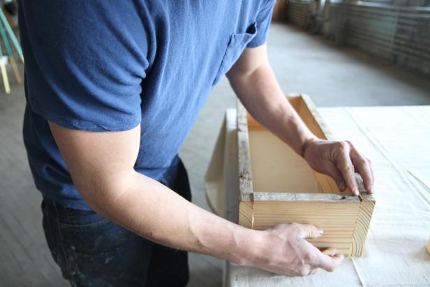To make the centerpiece base, fit wood pieces together to create a rectangular shape.