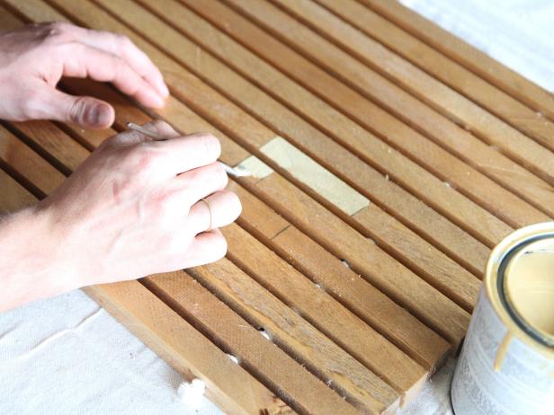 Use a detail brush to paint a monogram on a wood doormat.