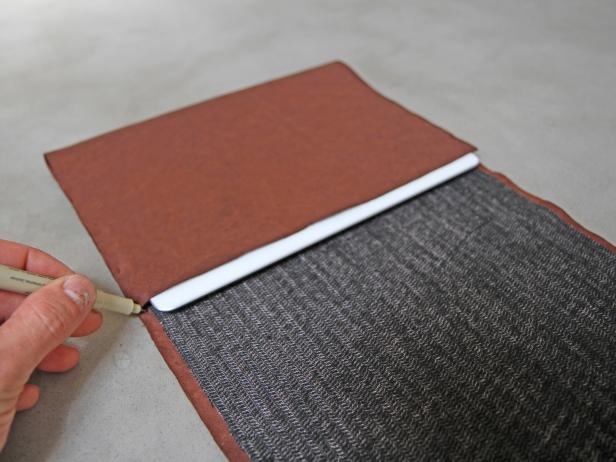 Place the iPad onto the fusing and fold the leather over, leaving the edge about 1/4" short of covering the iPad completely. Mark the corners on each side with a fabric pen.