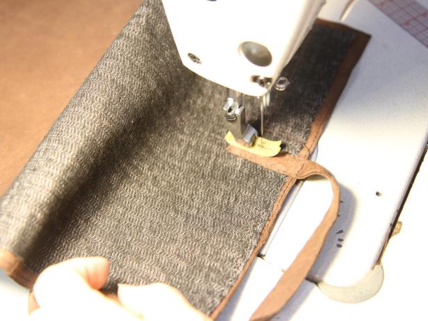 Sew leather strip to case using a sewing machine.