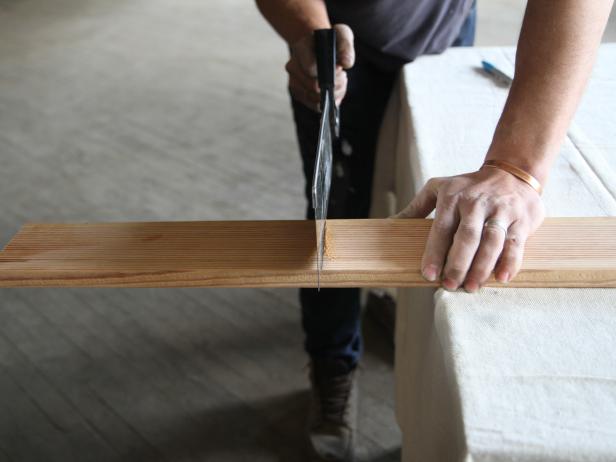 Cut a wood plank at 12" using a hand saw until you have four pieces.