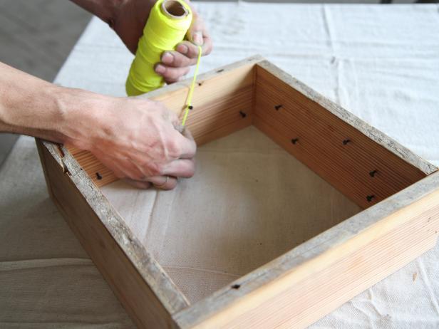 Attach string to carpet tack by tying a knot.
