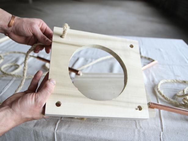 Attach second wood piece to the planter by sliding it onto the ropes.