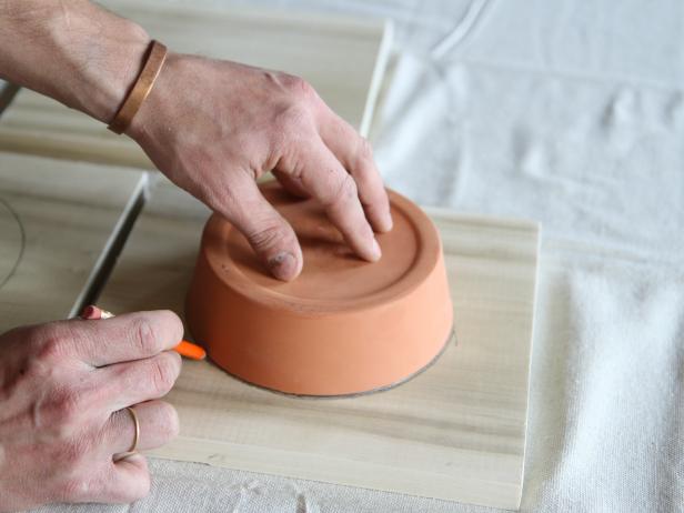 Trace a circle on the piece of poplar wood using a terra cotta pot.