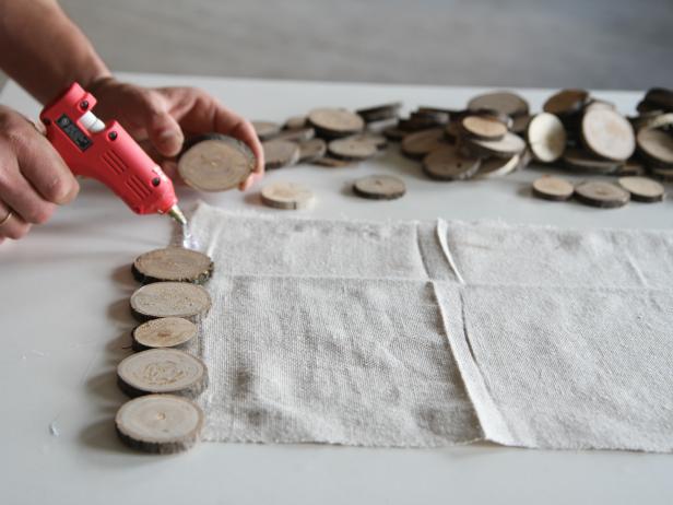Attach wood slices to drop cloth using a hot glue gun.