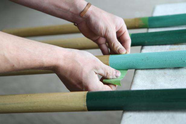 Remove painter's tape from coat rack legs after the paint dries.