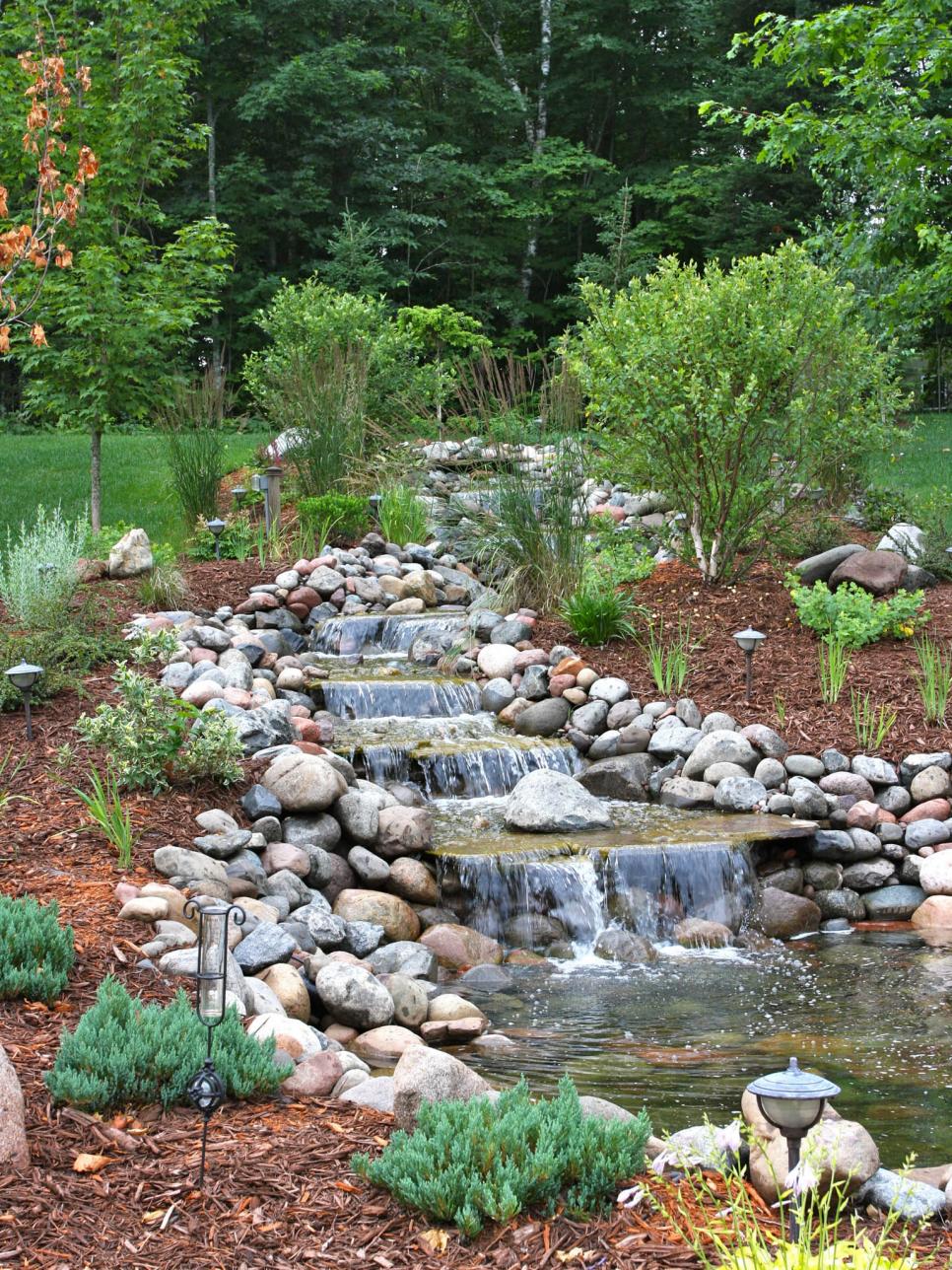 Backyard Waterfalls Ideas layered stone waterfall in a corner of a backyard Waterfall Designs Hgtv Backyard Waterfalls Ideas 25 best ideas about waterfall design on pinterest koi pond design small backyard ponds and diy waterfall Waterfall Designs Hgtv