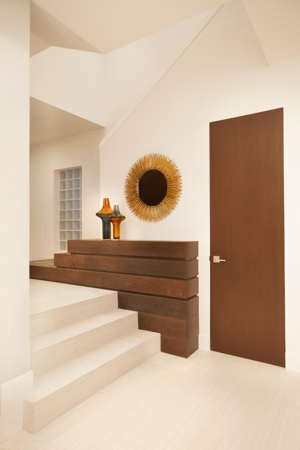 Geometric Foyer Feels Modern and Artistic Neutral Modern Entry With Brown Door, Sunburst Mirror & Block Shelves