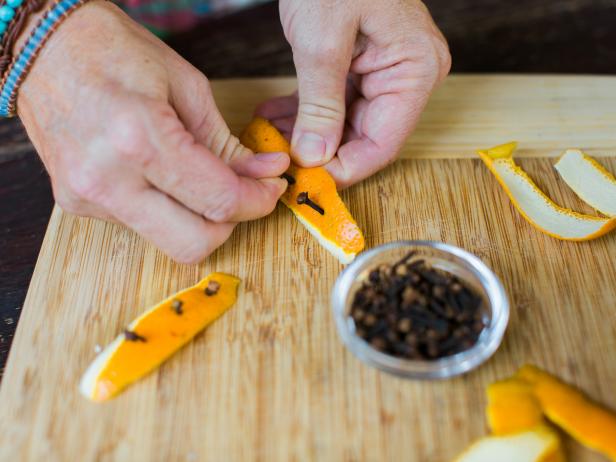 Using a vegetable peeler, peel orange strips, then push whole cloves into the peels.