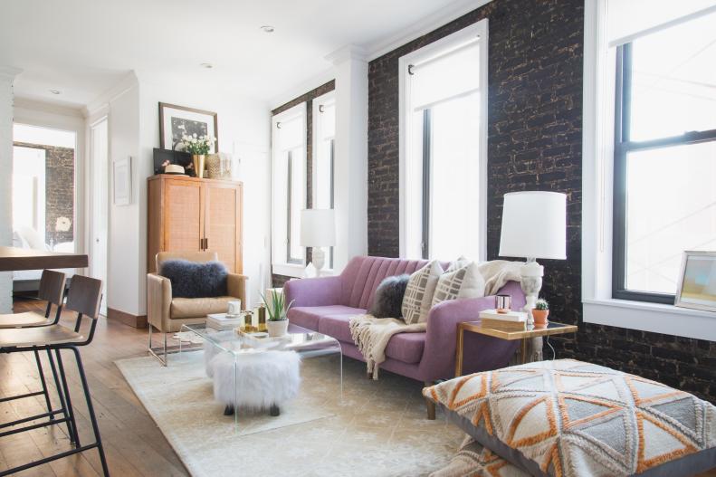 Urban Living Room With Dark Exposed Brick Wall and Purple Sofa
