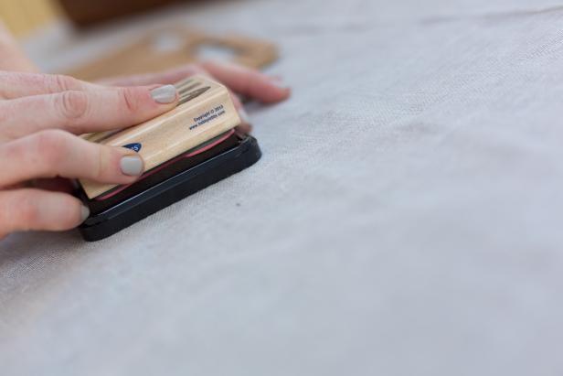 Press the rubber stamp evenly into the ink pad so there’s a solid coating on the stamp.
