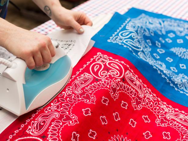 Roll out the webbing tape along one edge of a red bandana and trim to size and attach using an iron.
