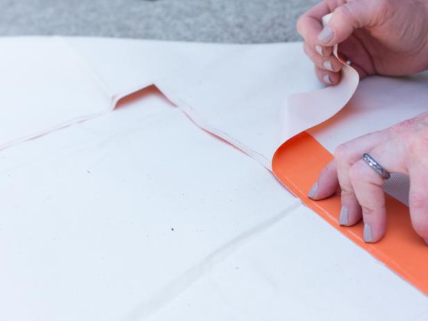 Flip drop cloth over and repeat, taking care to line up excess tape.
