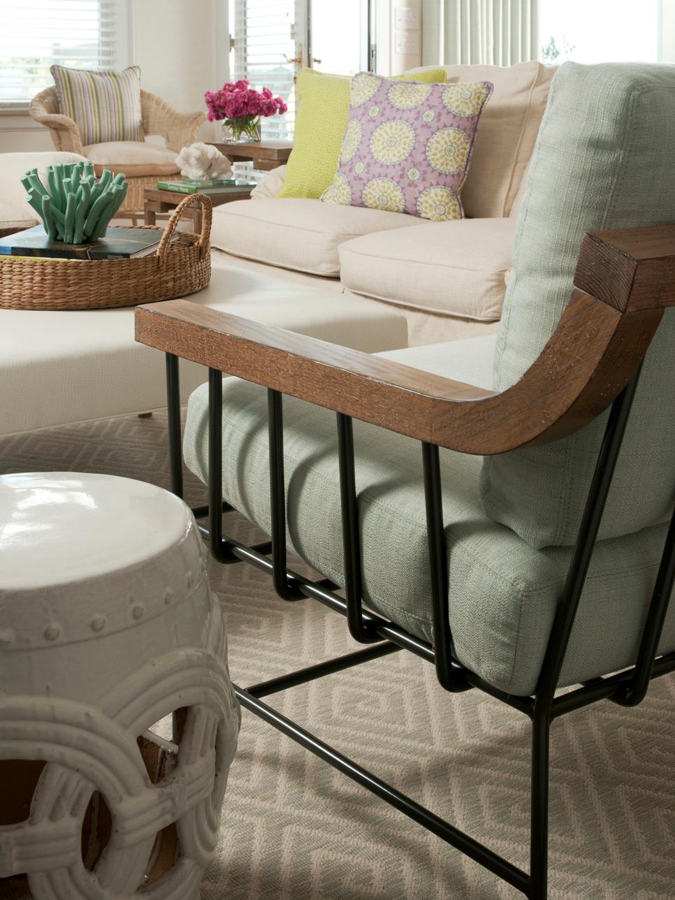 Coastal Living Room Boasts Trendy Touches Black Metal Armchair With Pale Green Cushions in Neutral Living Room