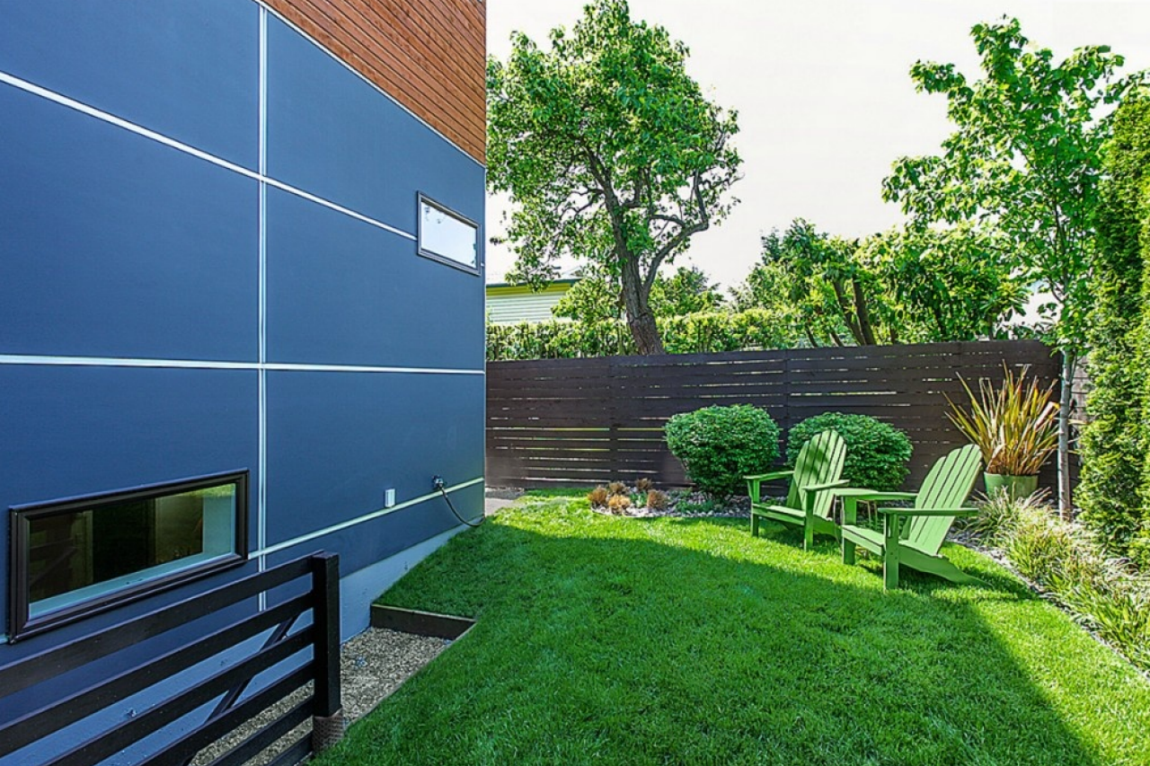 side yard with green adirondack chairs a lush green lawn makes a 