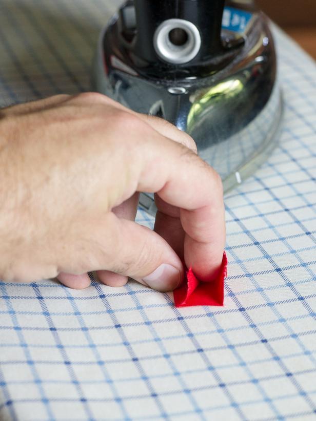 Cut a piece of red fabric that's 2-1/4" square. Fold it in thirds creating a strip of fabric 2-1/4" long and about 7/8" high. Iron the folds.