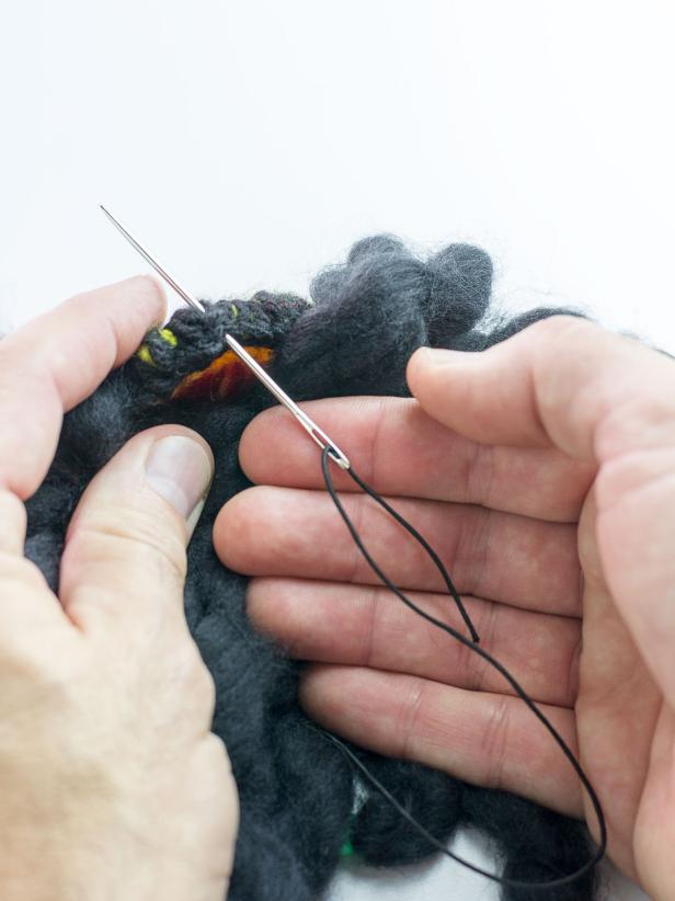 Stitch a 5-6 inch piece of elastic cord (depending on the size of your pet's head) through one side of the hat and tie a knot. Repeat for the other side to create a chin strap that will comfortably keep the hair and hat in place on your pet.