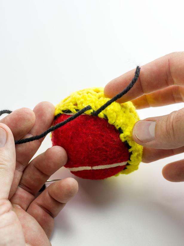 Continue stitching the black yarn through the lowest and highest part of the doily's edge all the way around to create the bottom shape of the hat. Pull snugly and tie with the tail from the initial knot.