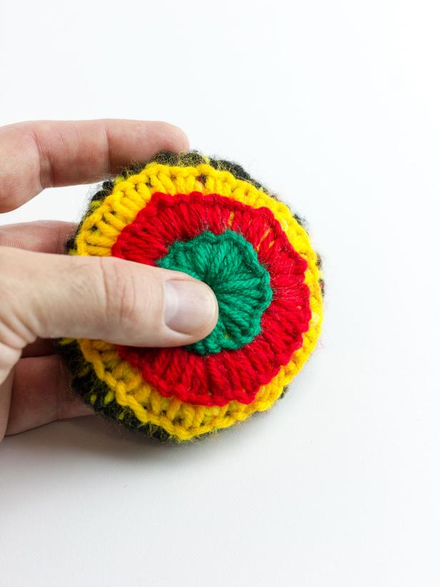 Continue stitching around the third circle of the doily with the red yarn. Tie off the end with green yarn and repeat the stitches for the center of the doily. Finish on the inside and tie a knot with one of the inside threads