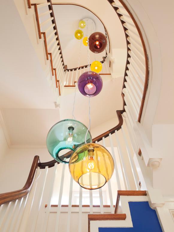 Tiered Chandelier With Colorful Pendants in Open Staircase