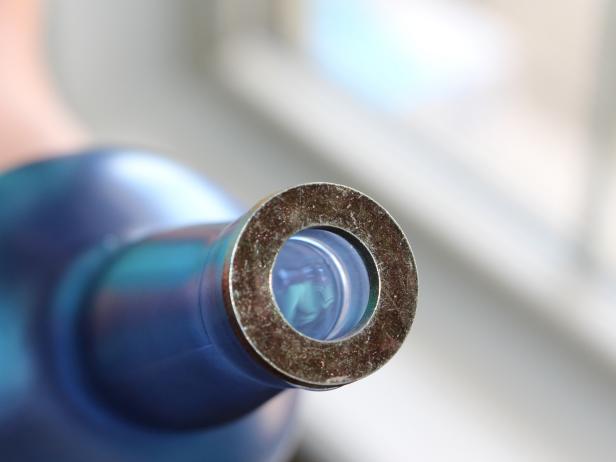 Run a thick line of hot glue around the opening of the bottle. Working quickly to ensure proper adhesion, attach washer to hot glue and center over opening. Tip: If copper coupling sits in the opening of the bottle without slipping, the washer is unnecessary and you can skip this step.