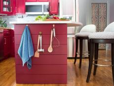 Kitchen Tools Hanging on Side of Red Kitchen Island With Barstools