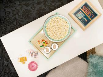 Layered Textured Rugs Under Dorm Room Table With White Tabletop and Gold and Turquoise Breakfast Tray 
