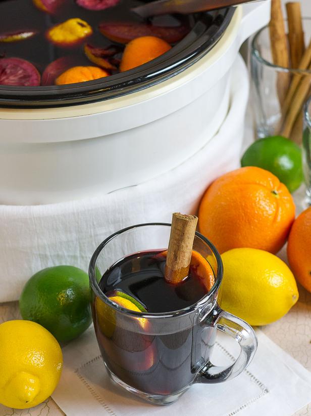 Slow Cooker Sangria With Cinnamon-Stick Garnish Next to Fruits