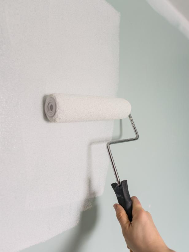 Vacuum and wipe down walls to make sure they are clean and free from splatters, toothpaste, etc. Remove all nails, mirrors, screws, wall light fixtures and switch plates. Patch holes with patching plaster or spackle and a putty knife. Allow spackle to dry and sand smooth with a drywall sanding block. Once wall is clean and smooth, use a roller and sash brush to apply wallpaper primer to walls. This will ensure good adhesion and easy removal down the road.
