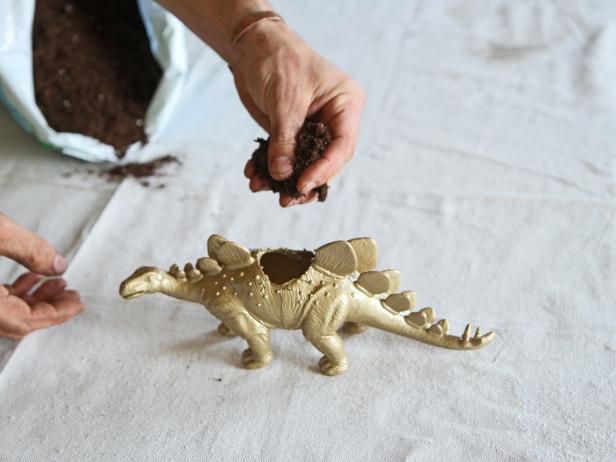 Fill the hollow animal planter with soil.