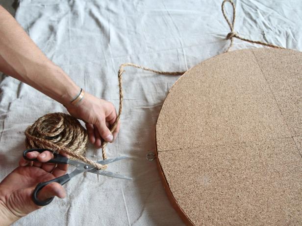 Cut off excess sisal rope after looping it through screw eyes.