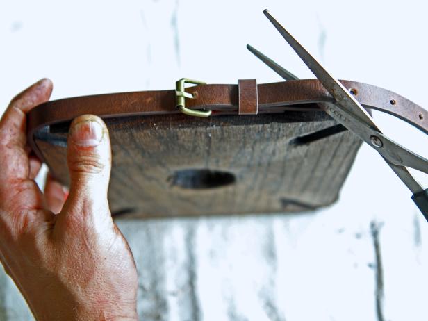 Secure the belt buckle by sliding the prong through the new drilled hole, and cut off the excess leather strap