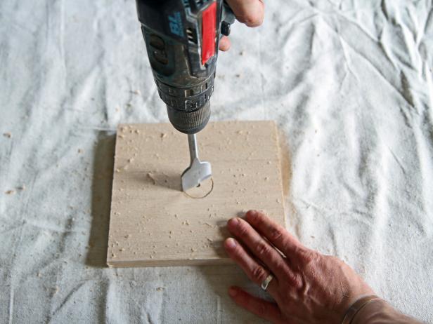 Drill a hole on the center mark of the wood piece using a 1 1/2” spade bit.