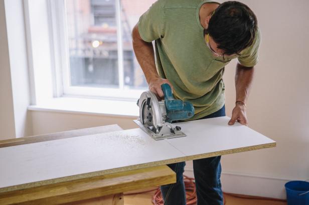 Cut melamine into four pieces to create a form for the concrete table.