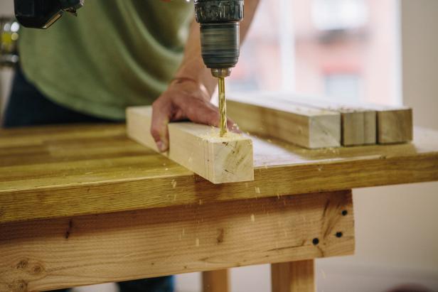 Drill holes in wood legs for threaded rods.