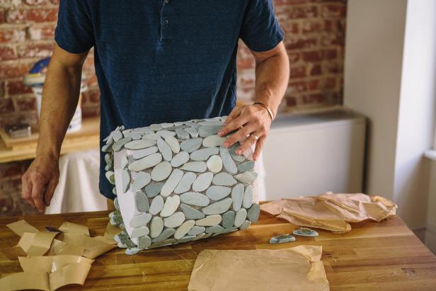 Attach stone tile sheets to the plastic bucket.