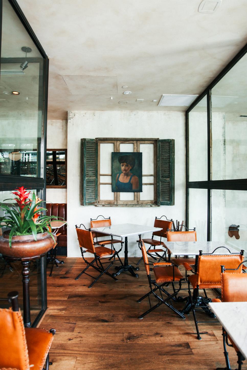 Vintage Window Frame Showcases Artwork Mexican Restaurant Dining Area With Metal and Orange Leather Chairs