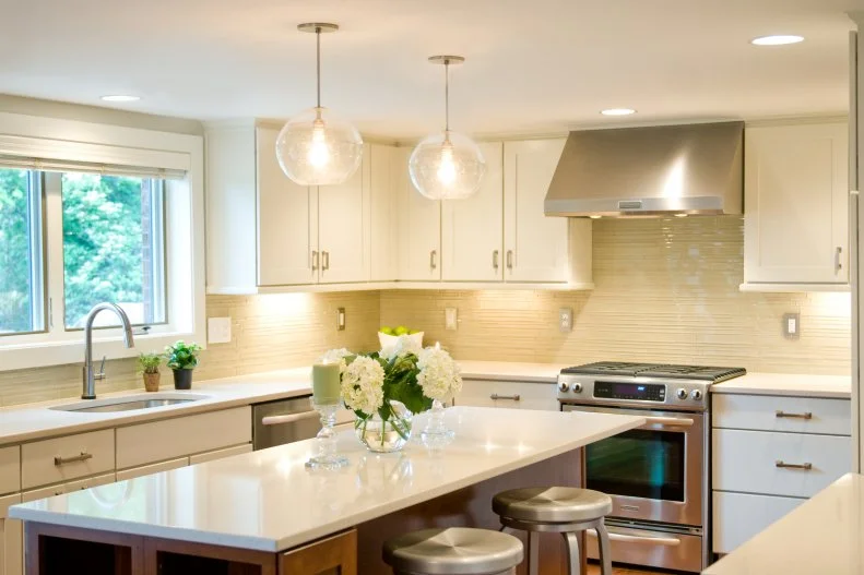 Wood-Toned Island in White Kitchen With Pendant Lights