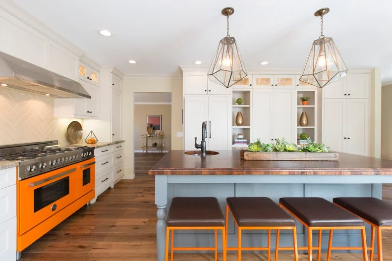 Kitchen with Orange Range and Island with Walnut Countertop