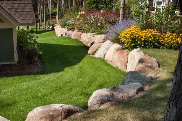 Gorgeous, Colorful Raised Flower Garden Lined With Large Rocks in Side Yard Gorgeous, Colorful Raised Flower Garden Lined With Large Rocks in Side Yard