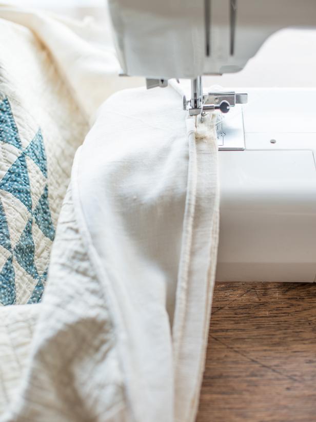 Turn slipcover inside out onto ottoman again. Pin piping that will run along bottom edge of ottoman side, where skirt will be attached. Sew it on and remove pins.