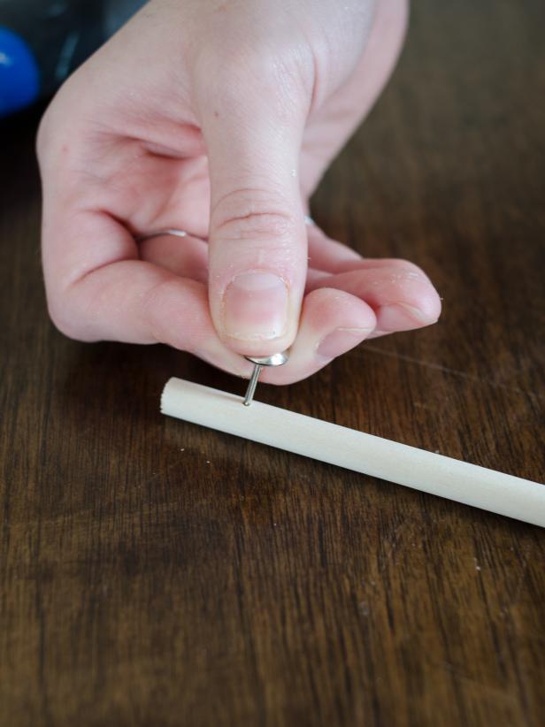 Cut a 5/16″ dowel to about 12″ – 14″ in length. (This can be done at home with a hand saw or at a hardware store.) Press silver upholstery tack gently into dowel, about 3/4″ from the top.