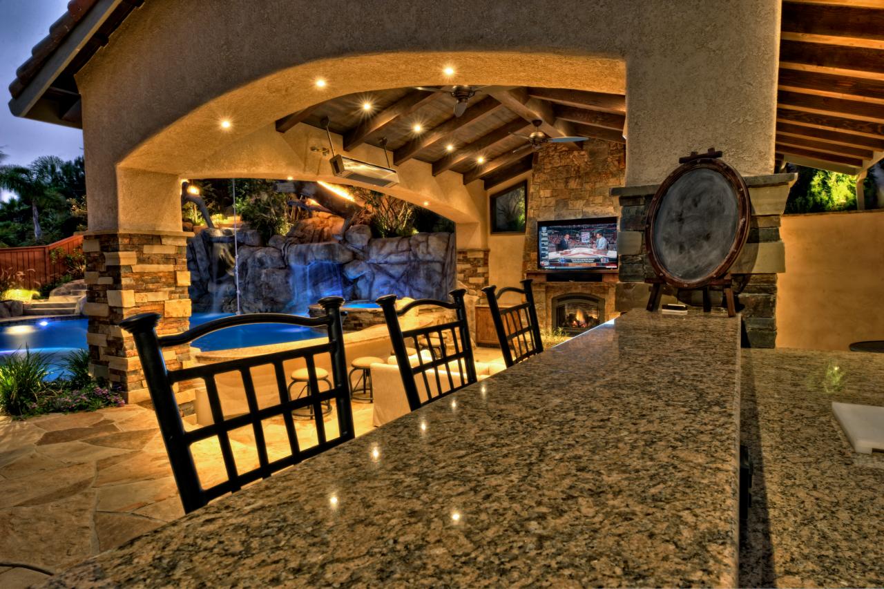 Granite Bar Sits Next To Outdoor Living Room Cabana and Pool with a